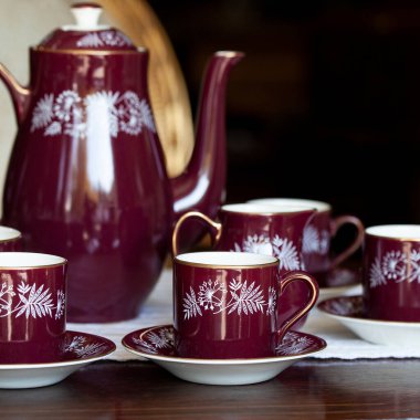 Ulusal boyalı antika koyu kırmızı porselen servisi. Lüks bir iç mekanda Ukrayna usulü hizmet. seramik yakın çekim