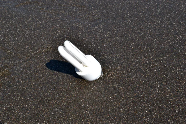 Ampoule blanche dans le sable — Photo