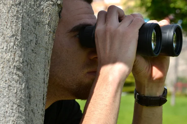 Uomo alla ricerca di un prismatico — Foto Stock