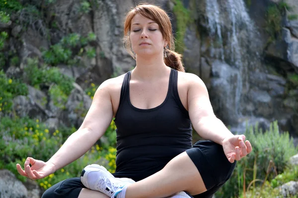 Mujer practicando yoga con fondo de cascada —  Fotos de Stock