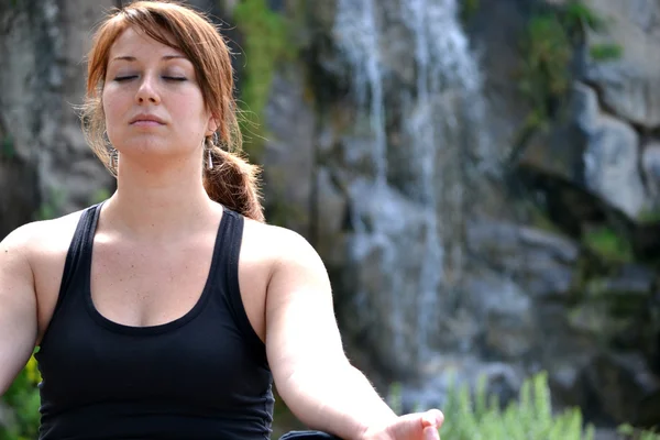 Mulher praticando ioga com fundo cachoeira — Fotografia de Stock