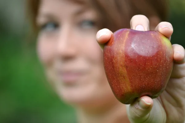 Νεαρή γυναίκα που δείχνει ένα μήλο — Φωτογραφία Αρχείου