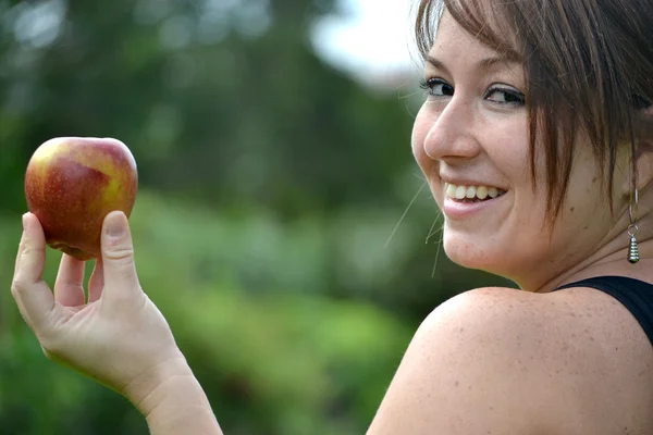 Mladá žena ukazuje apple — Stock fotografie
