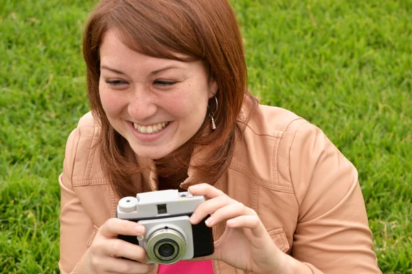 Jovem mulher tirando fotos com uma câmera velha — Fotografia de Stock