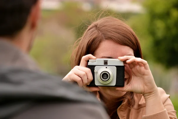 Jovem mulher tirando fotos com uma câmera velha — Fotografia de Stock