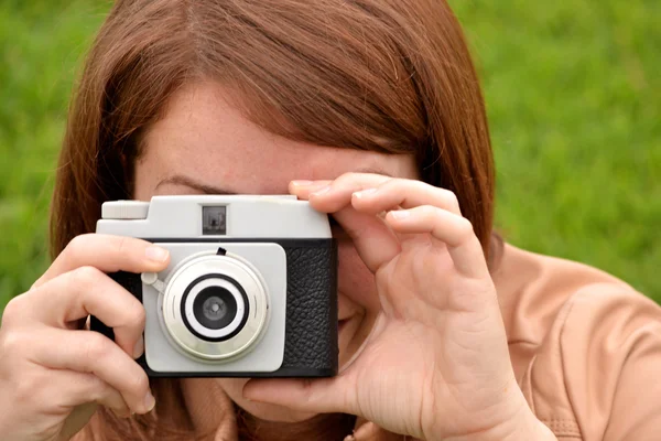 Молодая женщина фотографирует старым фотоаппаратом — стоковое фото