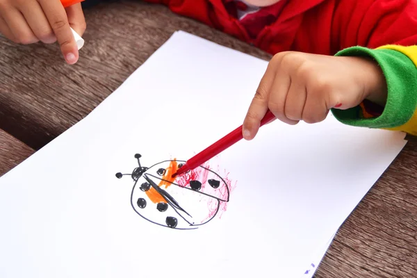 Ребенок рисует божью коровку — стоковое фото