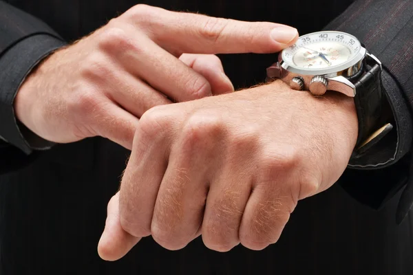 Geschäftsmann zeigt auf eine Uhr — Stockfoto