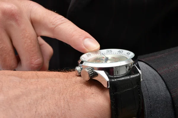 Hombre de negocios apuntando a un reloj — Foto de Stock