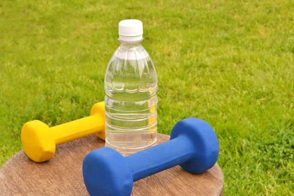 Bottle and dumbbell — Stock Photo, Image