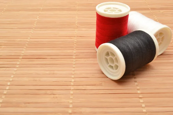 Sewing threads on wood — Stock Photo, Image