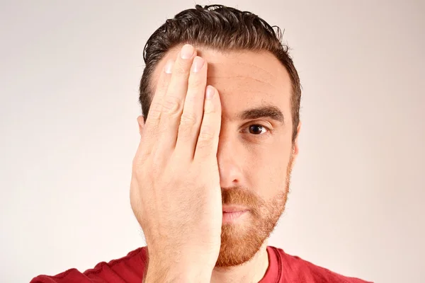 bir gözün elle kapsayan adam