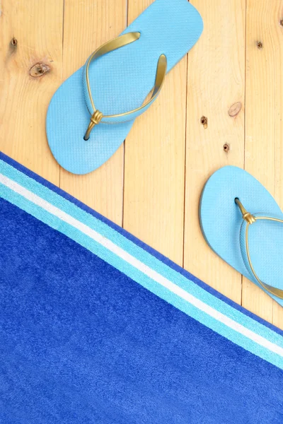 Ręcznik i plaży klapki na drewno — Zdjęcie stockowe