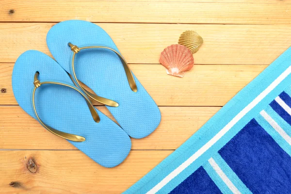 Towel and beach slippers on wood — Stock Photo, Image