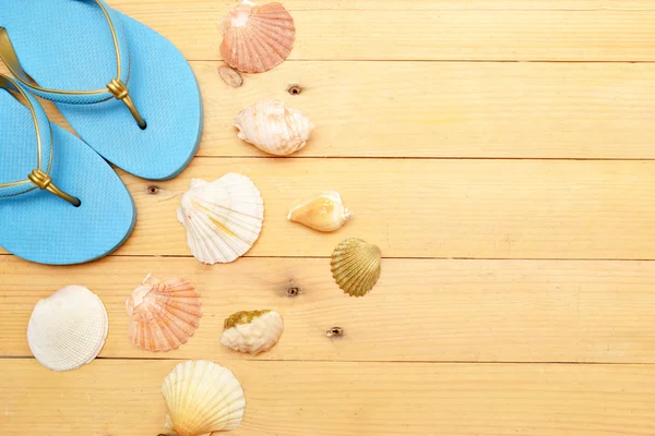 Beach slippers and shells on wood — Stock Photo, Image