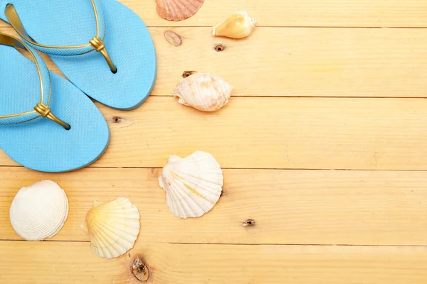 Beach slippers and shells on wood — Stock Photo, Image