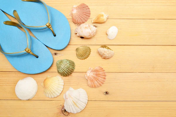 Beach slippers and shells on wood — Stock Photo, Image