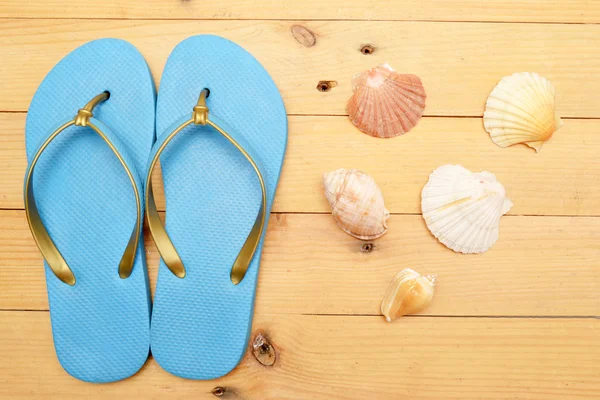 Zapatillas de playa y conchas en madera —  Fotos de Stock