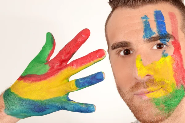 Man looking into the camera with painted hands — Stock Photo, Image