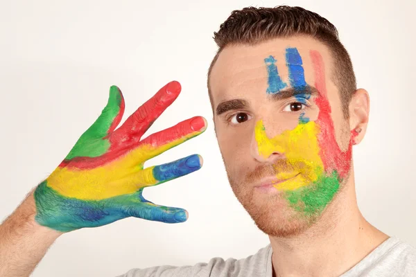 Man looking into the camera with painted hands — Stock Photo, Image