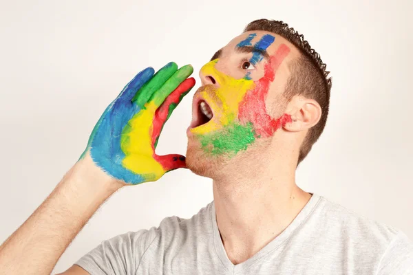 Jonge man schreeuwen met de hand geschilderd gezicht — Stockfoto