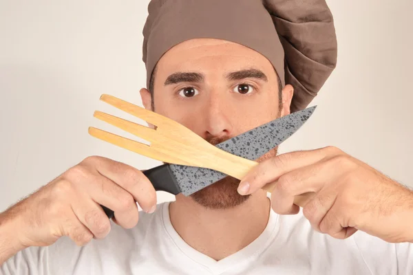 Cocine con un cuchillo y tenedor manos de madera —  Fotos de Stock