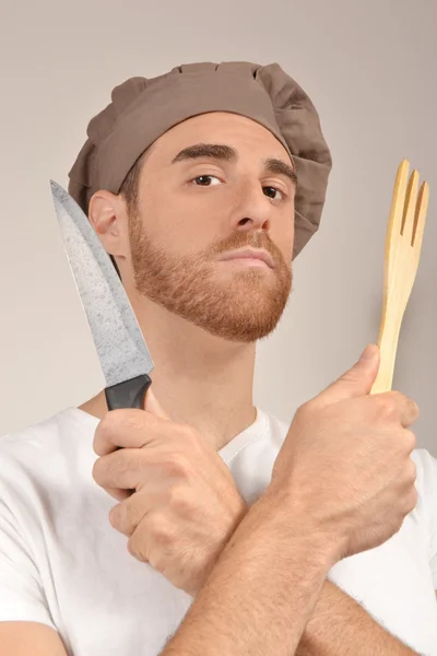 Cozinhe com uma faca e garfo mãos de madeira — Fotografia de Stock