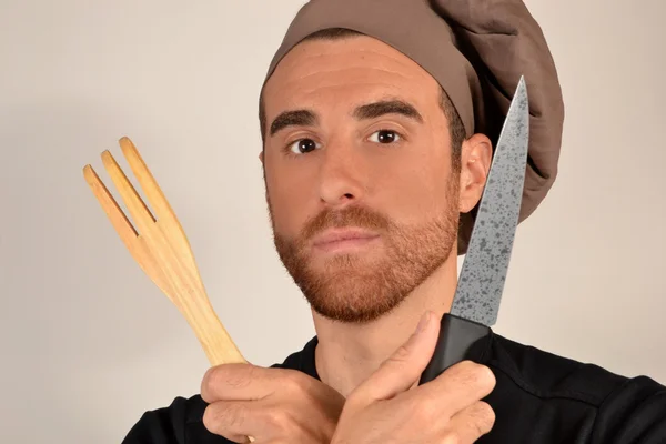 Cocine con un cuchillo y tenedor manos de madera — Foto de Stock