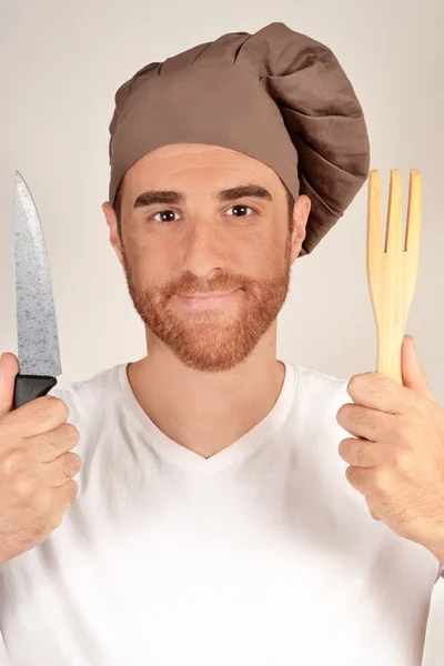 Cocine con un cuchillo y tenedor manos de madera — Foto de Stock