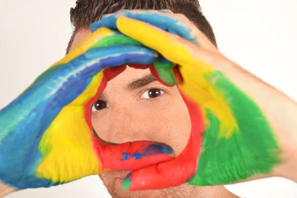 Man looking into the camera with painted hands — Stock Photo, Image