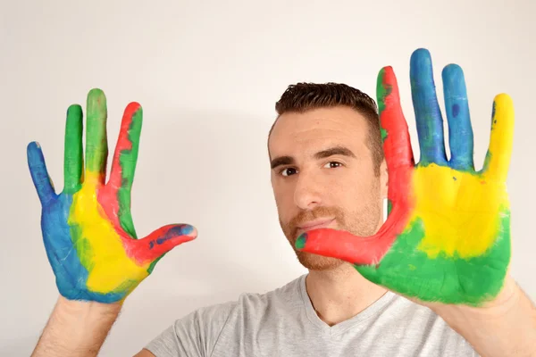 Man looking into the camera with painted hands — Stock Photo, Image