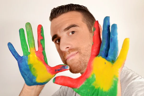 Man looking into the camera with painted hands — Stock Photo, Image