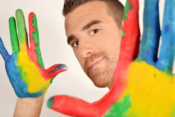 Man looking into the camera with painted hands — Stock Photo, Image