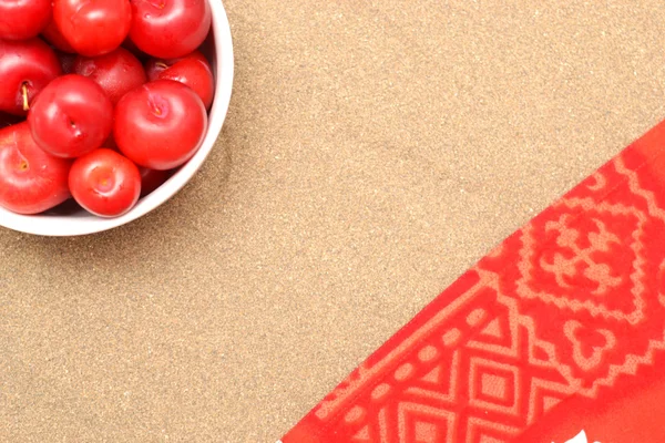 Red plums on sand on summer — Stock Photo, Image