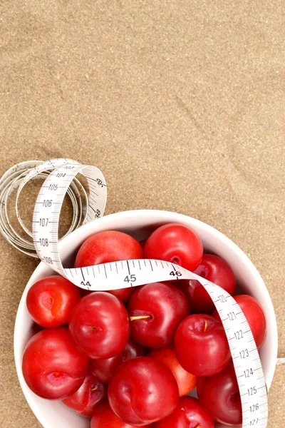Prunes rouges et ruban à mesurer — Photo