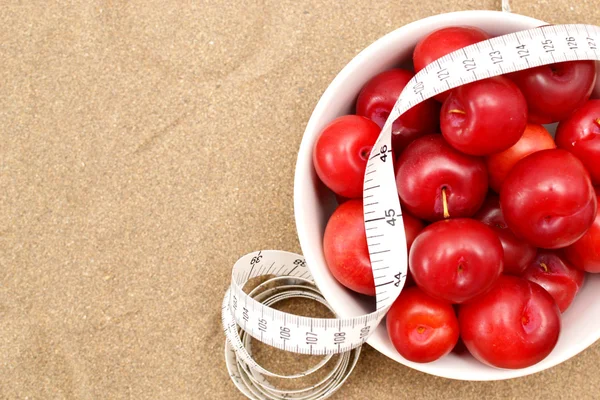 Ciruelas rojas y cinta métrica — Foto de Stock