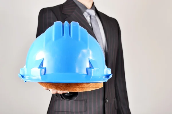 Businessman showing a helmet — Stock Photo, Image