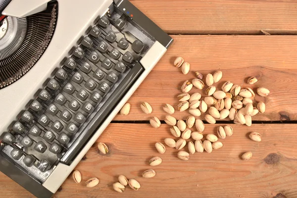 Typewriter and pistachios — Stock Photo, Image