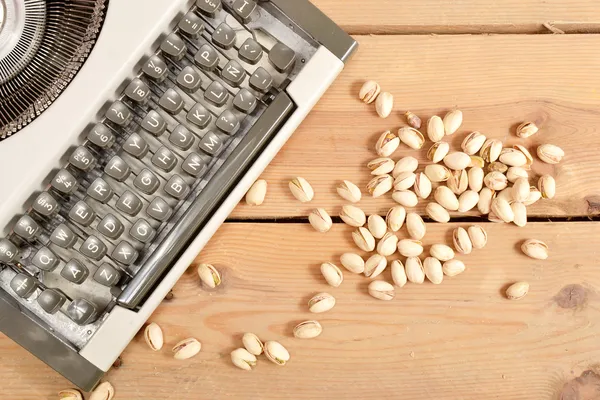 Typewriter and pistachios — Stock Photo, Image