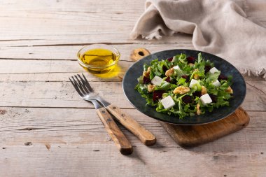 Pancar salatası, beyaz peynir, marul ve ahşap masada ceviz.