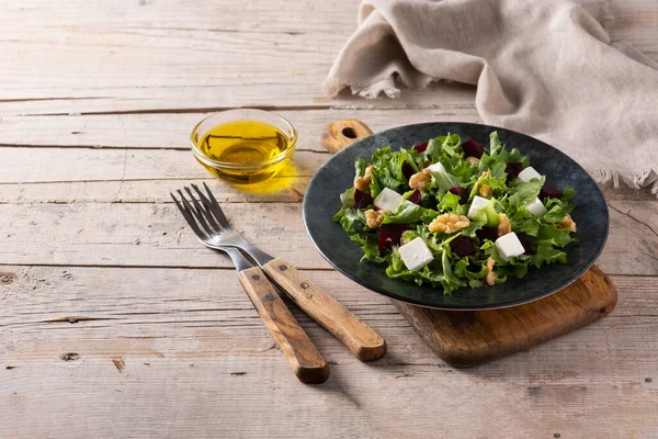 Pancar salatası, beyaz peynir, marul ve ahşap masada ceviz.