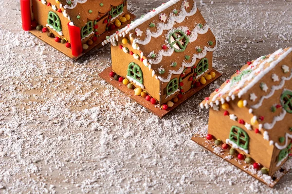 Christmas gingerbread house decorated with candies and glaze on wooden table