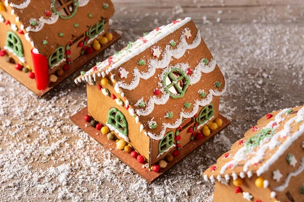 Christmas gingerbread house decorated with candies and glaze on wooden table