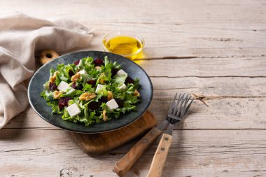 Pancar salatası, beyaz peynir, marul ve ahşap masada ceviz.