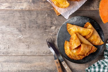 Ahşap masada balkabağı empanadillası