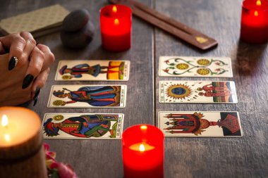 Falcı köy masasında tarot kartlarıyla geleceği okuyor.