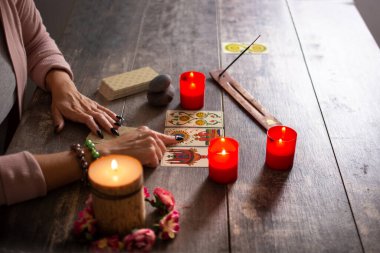 Falcı köy masasında tarot kartlarıyla geleceği okuyor.
