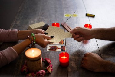 Falcı köy masasında tarot kartlarıyla geleceği okuyor.