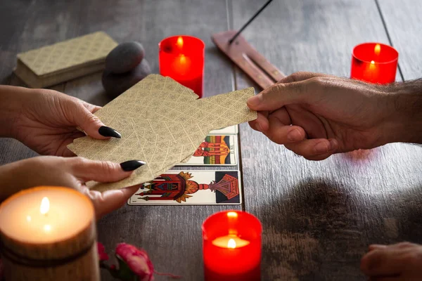 Falcı köy masasında tarot kartlarıyla geleceği okuyor.