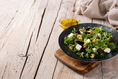 Beyaz peynirli pancar salatası, marul ve ceviz kırsal ahşap masa. Boşluğu kopyala.